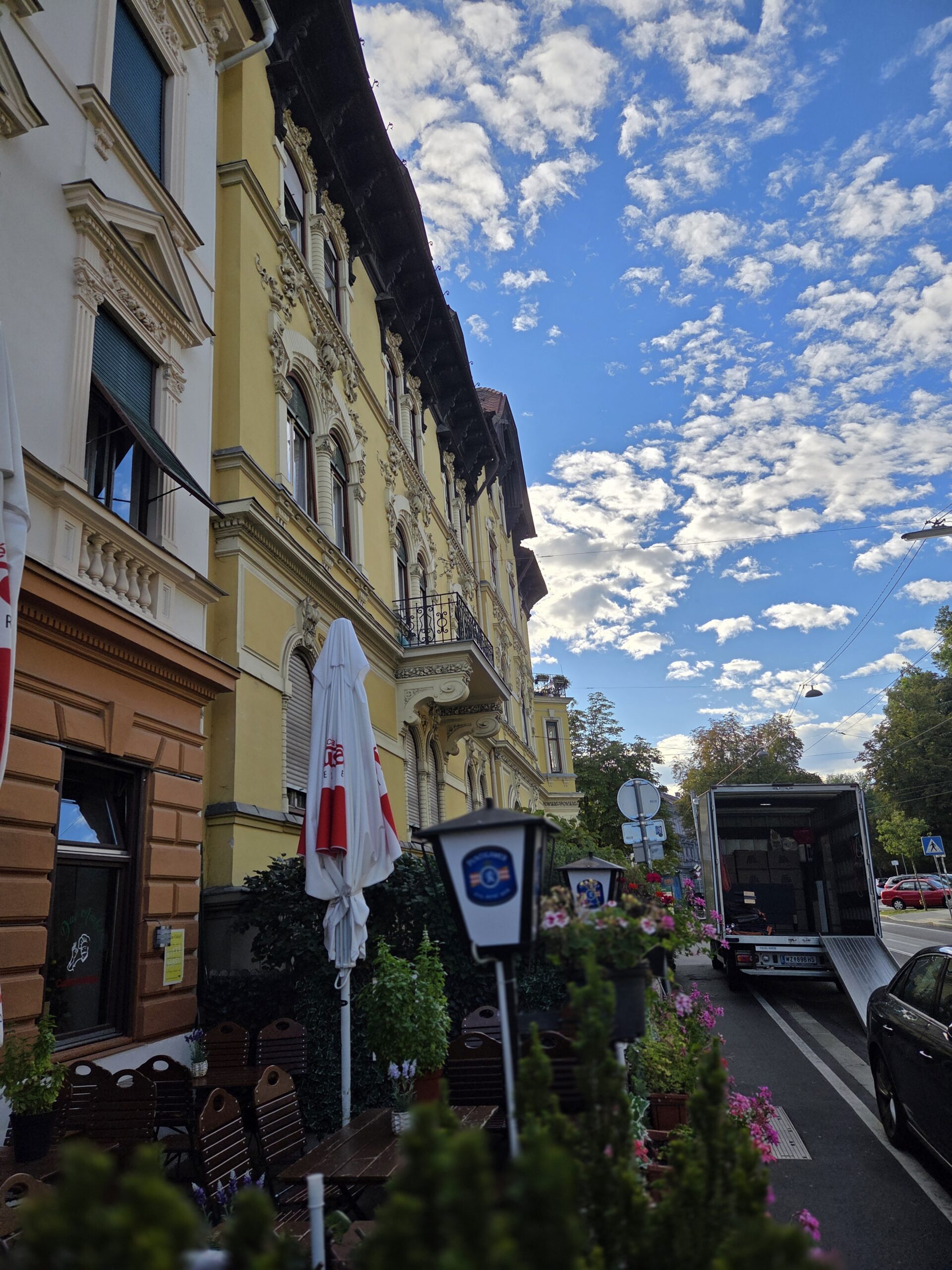 Umzugs-LKW mit Laderampe vor einer Häuserzeile in Graz